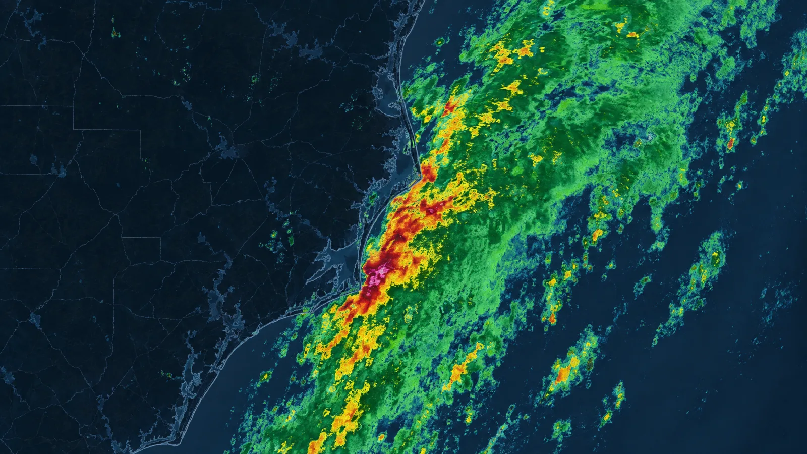 Illustration of a squall line on a weather radar composite — a diagonal band of green, amber, and red precipitation moving in from open water onto a dark coastline
